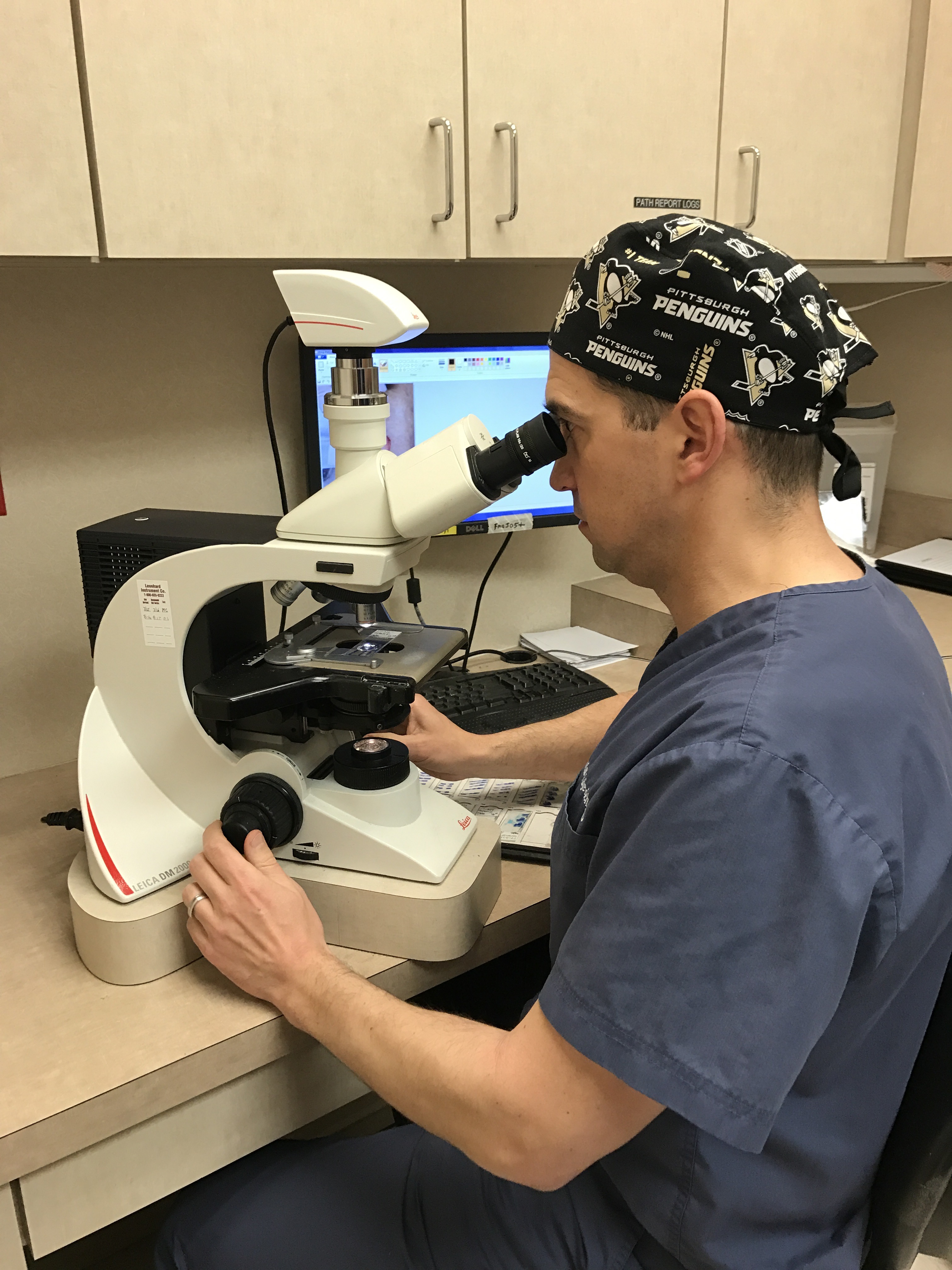 Dr. Justin Vujevich examining tissue at the microscope.